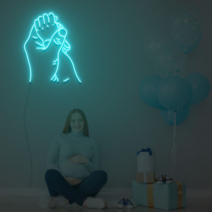 Hand eines Erwachsenen hält Babyhand LED-Neonschild für Kinderzimmer Babyshower