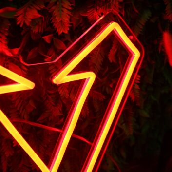Modernes LED Neonschild V Symbol mit Blitz Design grafisches Neon Wandlicht als dekorative Innenraumbeleuchtung