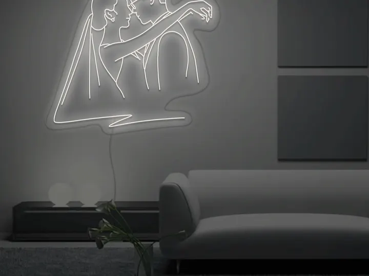 Weißes LED-Neonschild mit umarmendem Brautpaar über einem Sofa